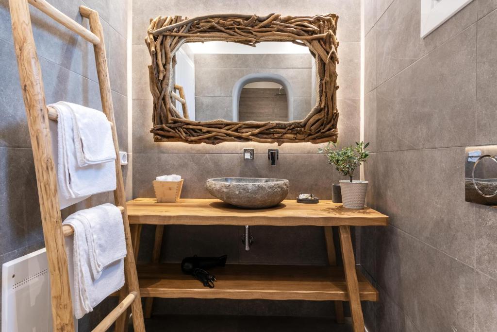 uma casa de banho com um lavatório e um espelho em Secret Garden Apartments em Míconos