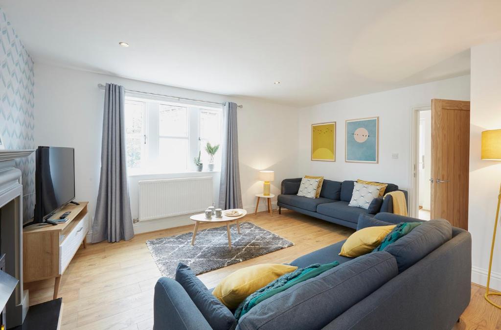 a living room with a blue couch and a tv at Listers Nest in Exley