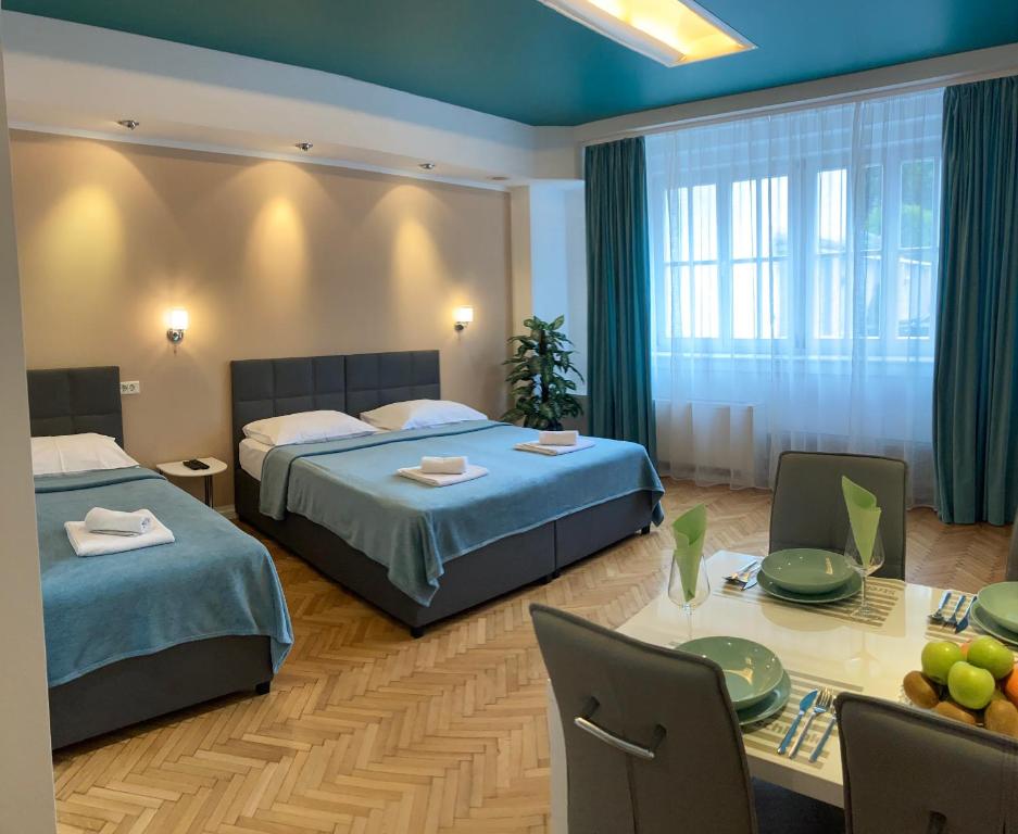 a hotel room with two beds and a table with chairs at Apartma City & Free Parking in Ljubljana