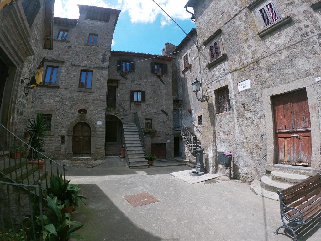 un callejón con dos edificios de piedra y un banco en B&B Il Grifo, en Bomarzo