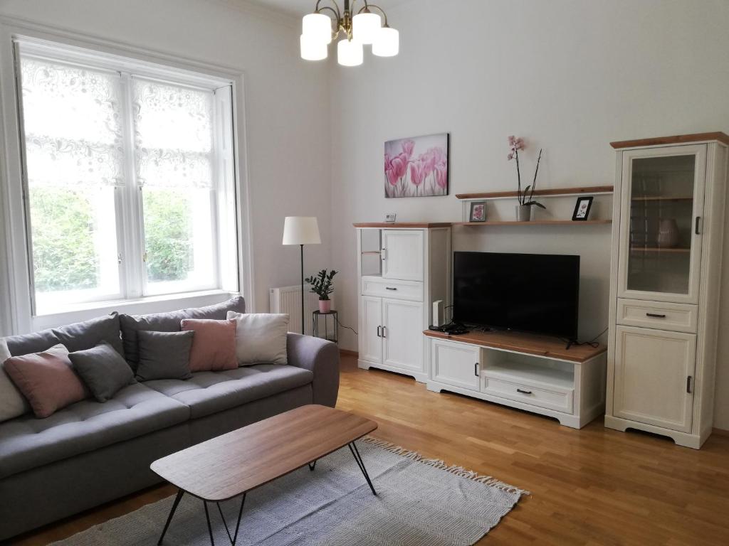 a living room with a couch and a tv at GOLD 2 Apartman in Sopron