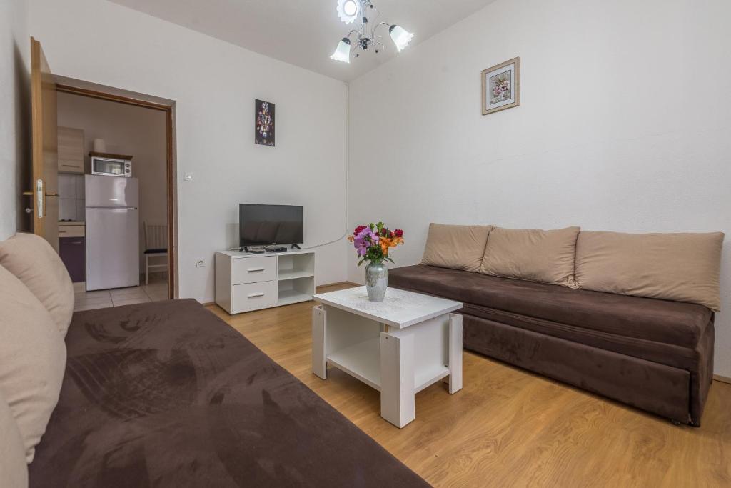 ein Wohnzimmer mit einem Sofa und einem Tisch in der Unterkunft Apartmani Mlinar9 #1 in Gornji Karin