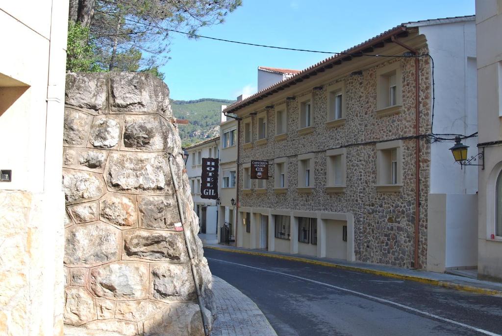 a stone wall next to a street with buildings at Hotel Gil in Montanejos