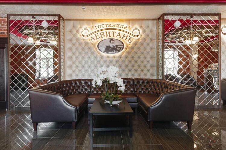 un restaurante con 2 sofás de cuero y una mesa en Hotel Levitan en Vladimir