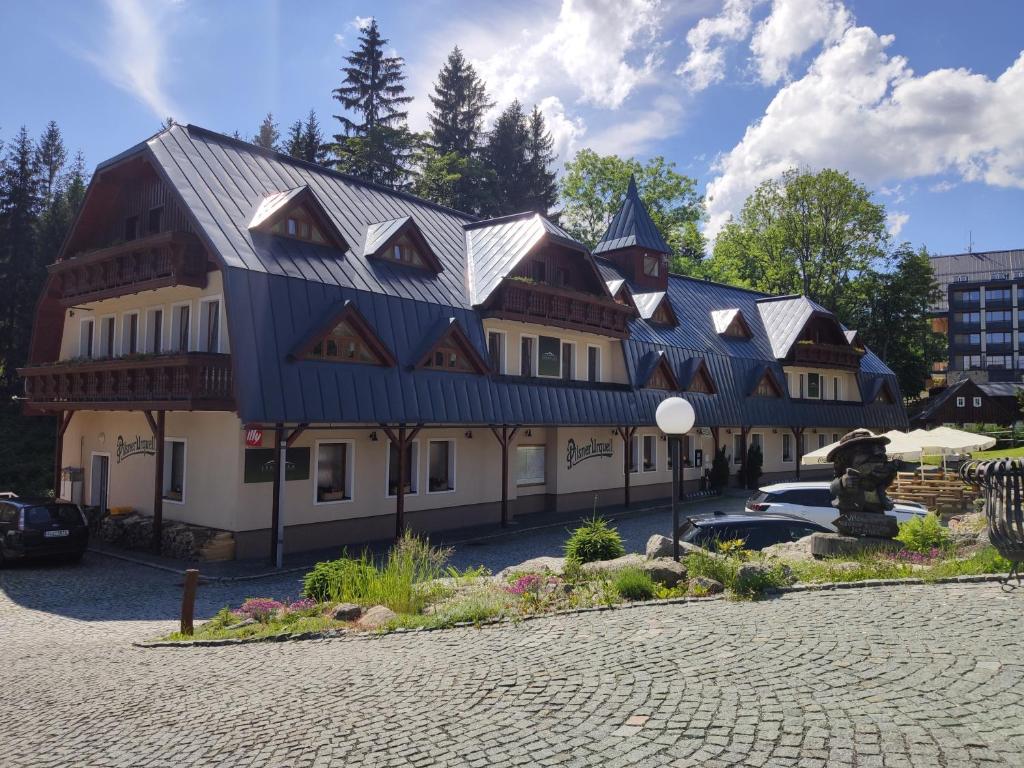 a large building with a blue roof at Wellness Penzion Jarmilka in Bedřichov