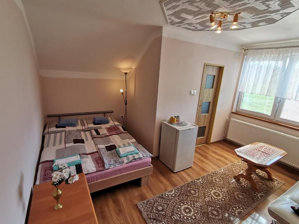 Dormitorio pequeño con cama y mesa en Privát u Bartolomeja en Štrba