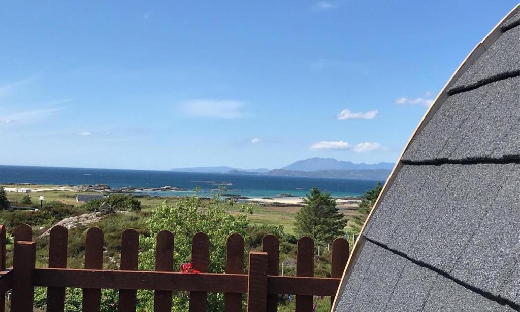 a surfboard sitting on top of a wooden fence at Arisaig Pods in Arisaig