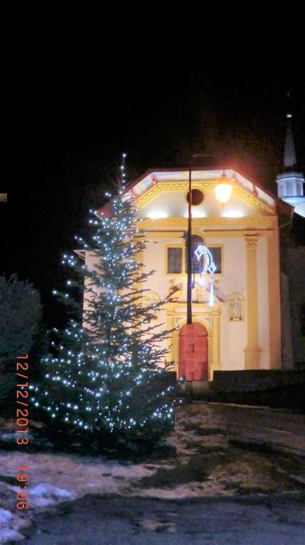 Un árbol de Navidad con luces delante de un edificio en Les Passereaux 2, en Saint-Gervais-les-Bains