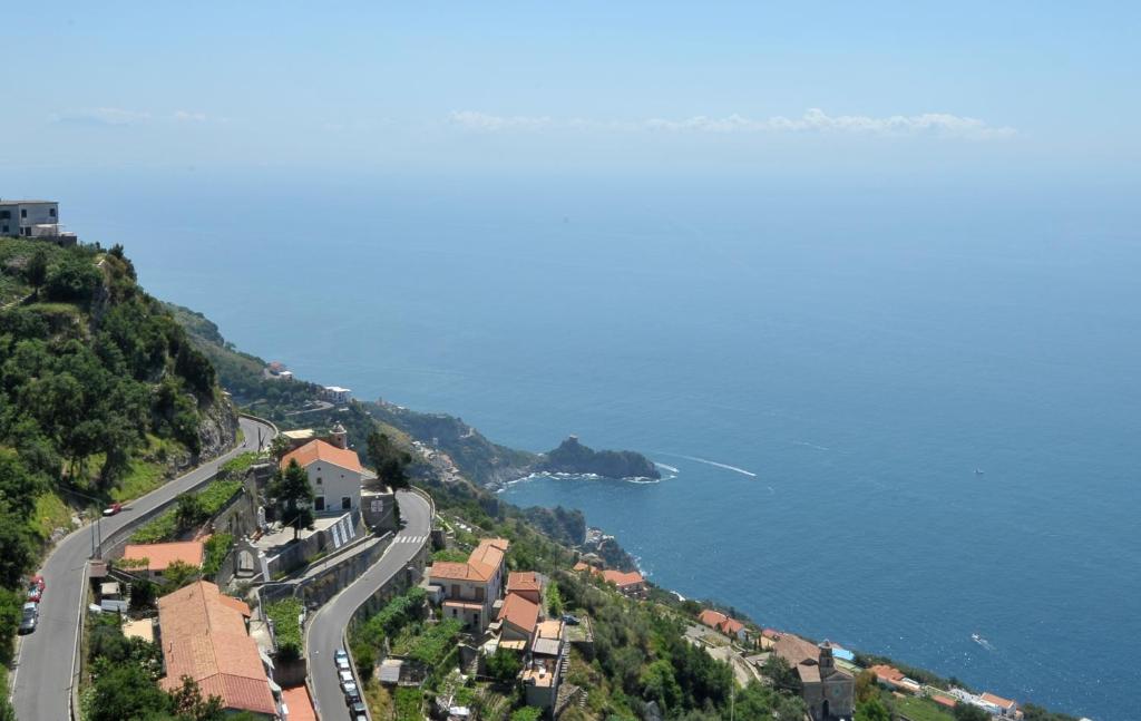 a winding road on a hill next to the ocean at La Rosa dei Venti in Furore