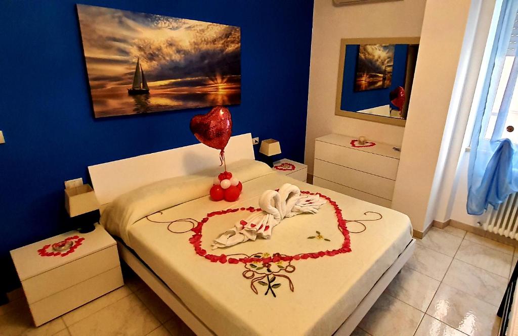 een slaapkamer met een bed met een hart gemaakt van rozen bij La casa di Cri con servizio spiaggia incluso! in San Benedetto del Tronto