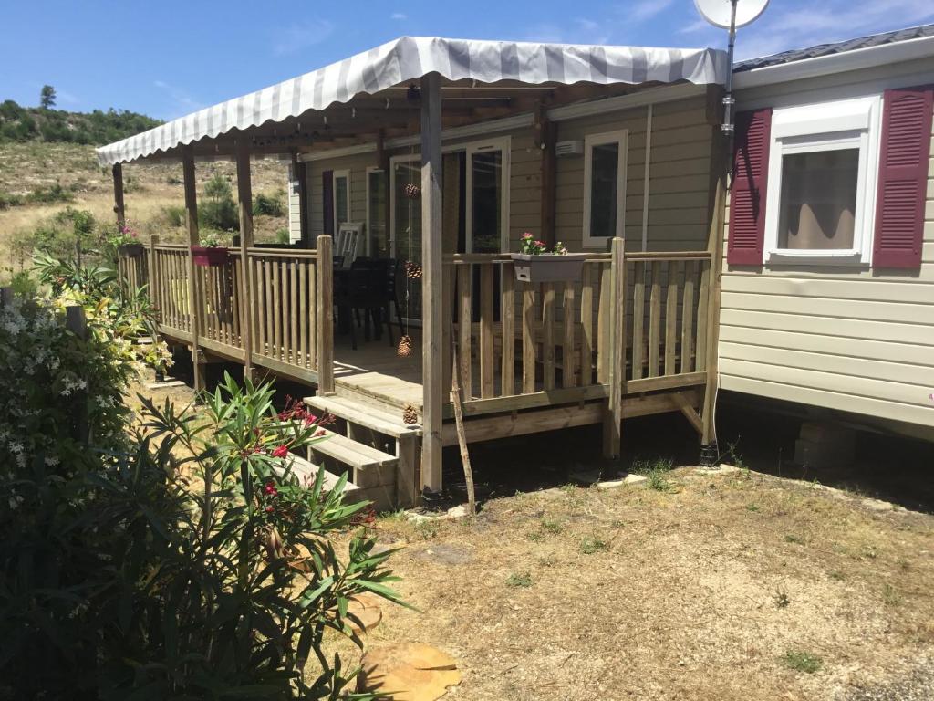 une petite maison avec un porche et une terrasse dans l'établissement MH 313 Les Dunes de Contis 3 chambres et 2salles de bain, à Saint-Julien-en-Born