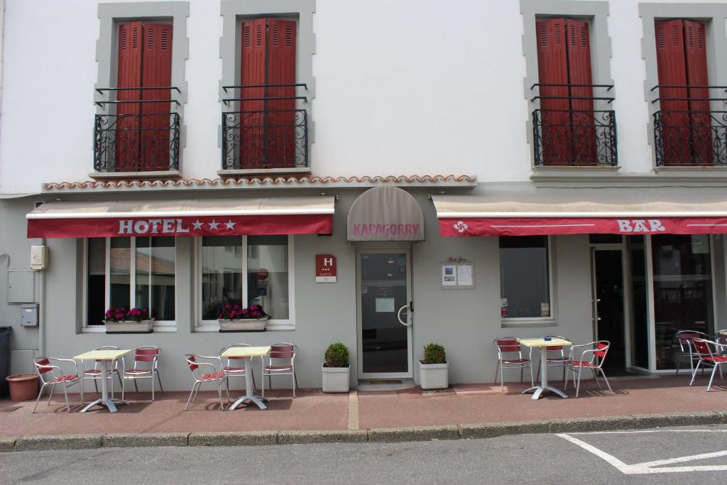 une rangée de tables et de chaises à l'extérieur d'un hôtel dans l'établissement Hotel Kapa Gorry, à Saint-Jean-de-Luz