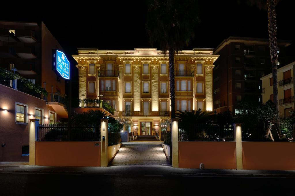 um edifício iluminado à noite com luzes em Hotel Careni Villa Italia em Finale Ligure