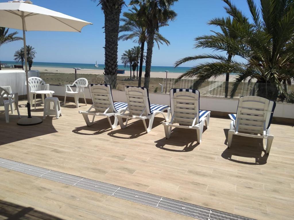 un grupo de sillas y una sombrilla en la playa en Los Frasquitos, en Vera