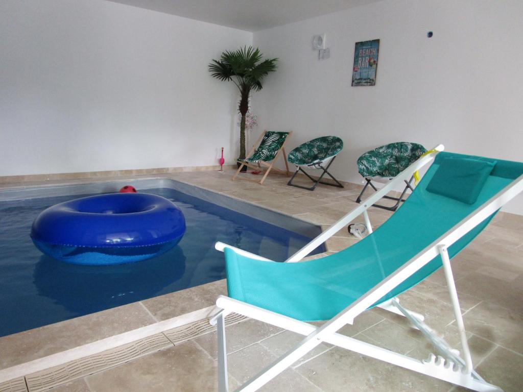 uma piscina com cadeiras e uma banheira azul em Fleur de Lys em Mer