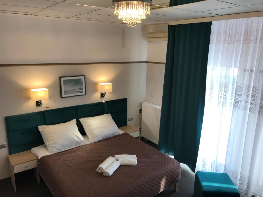 - une chambre avec un lit et 2 serviettes dans l'établissement Hotel & Restauracja Glass, à Radom