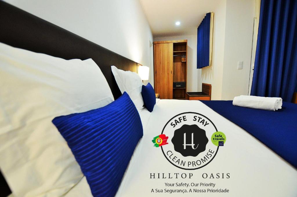 a hotel room with a bed with a blue cover at HILLTOP OASIS Lisbon Lux Oeiras in Oeiras