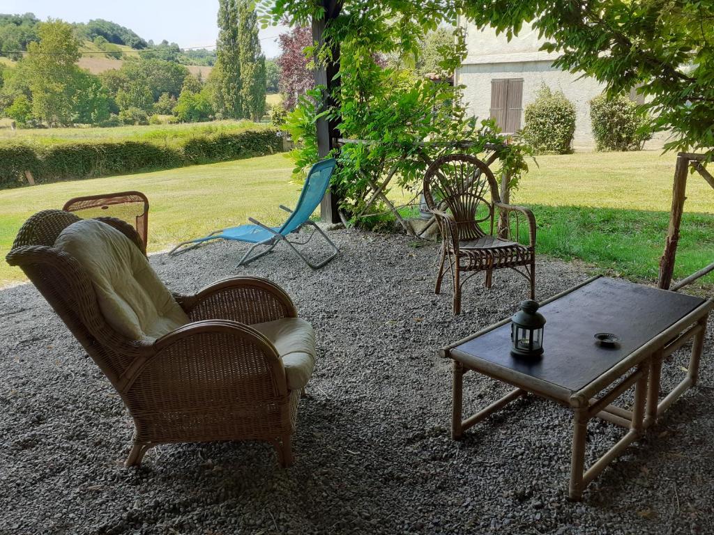 a group of chairs and a coffee table in a yard at La Grange in Le Plan
