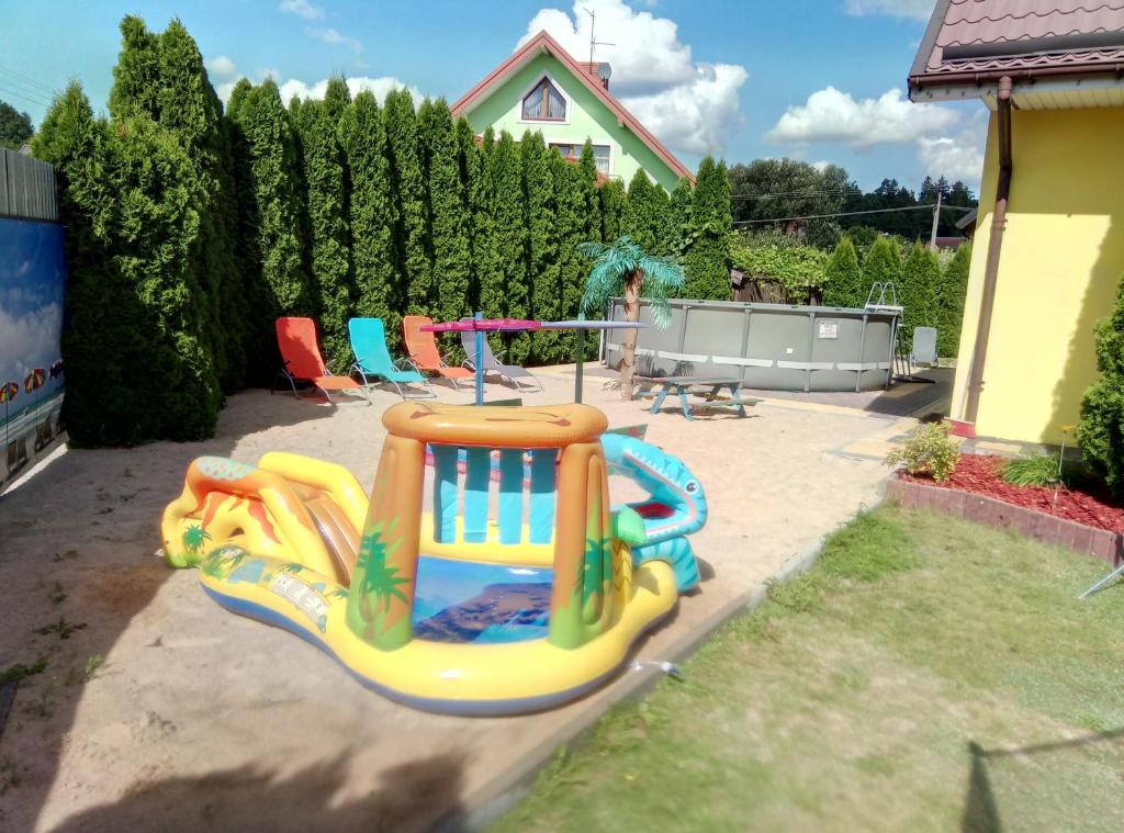 un patio trasero con un parque infantil con una casa hinchable en Willa u Andrzeja, en Gołdap