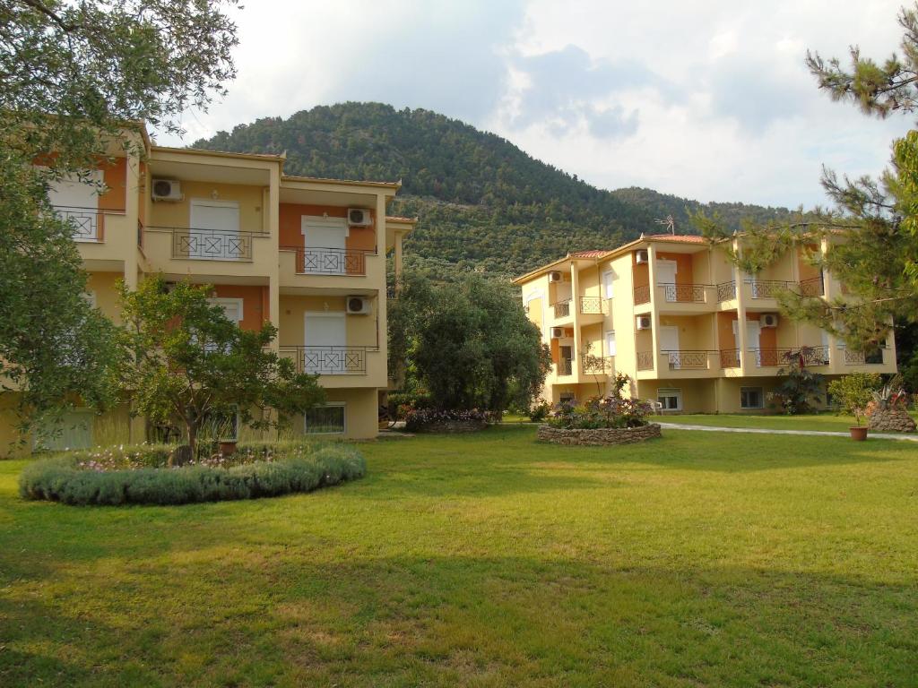 a row of apartment buildings with a yard at Nostos Studios Golden Beach in Chrysi Ammoudia