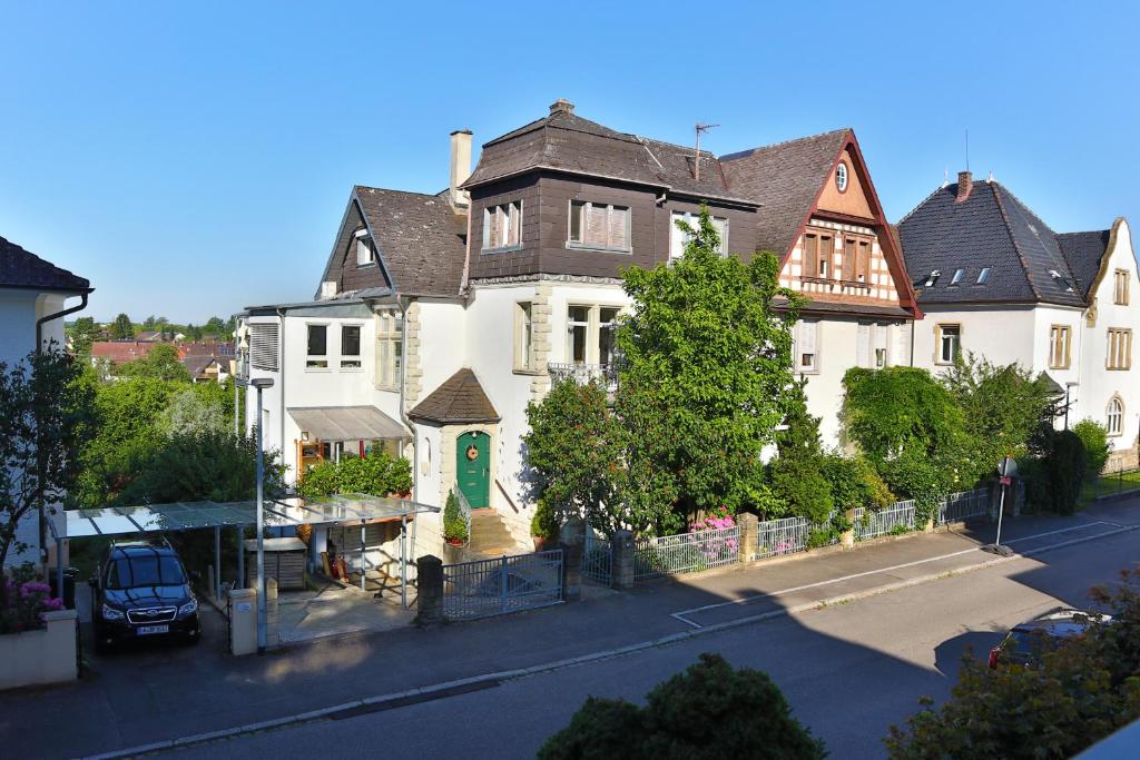 a large white house with a green door on a street at VILLA14 in Offenburg