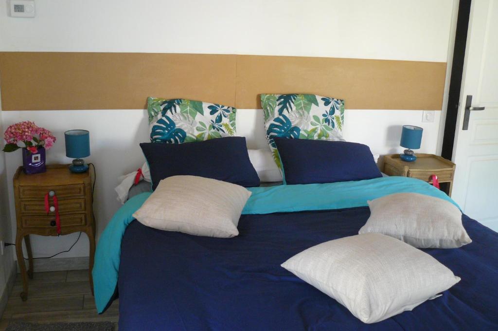 un grande letto blu con due cuscini sopra di Le fief Beaurepaire 76280 a Beaurepaire