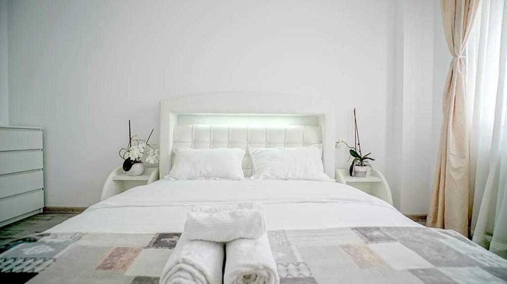Un dormitorio con una cama blanca con toallas. en Giorgia and Ary, en Brasov