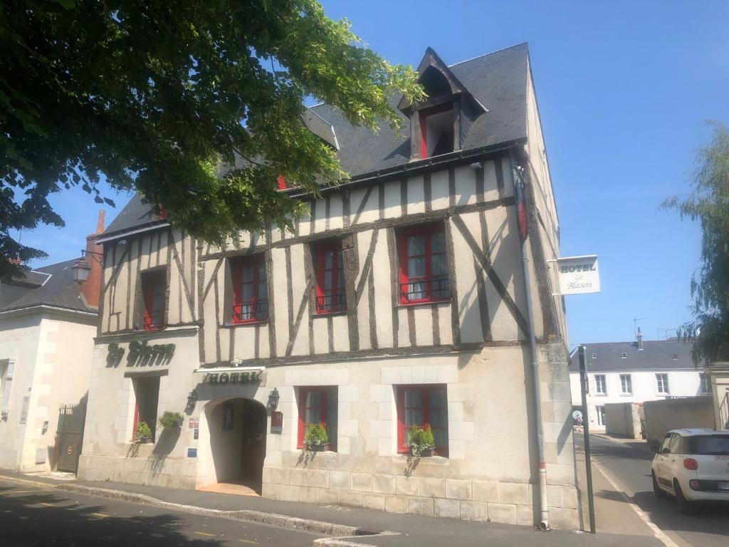 a black and white building with red windows at Hôtel Le Blason in Amboise