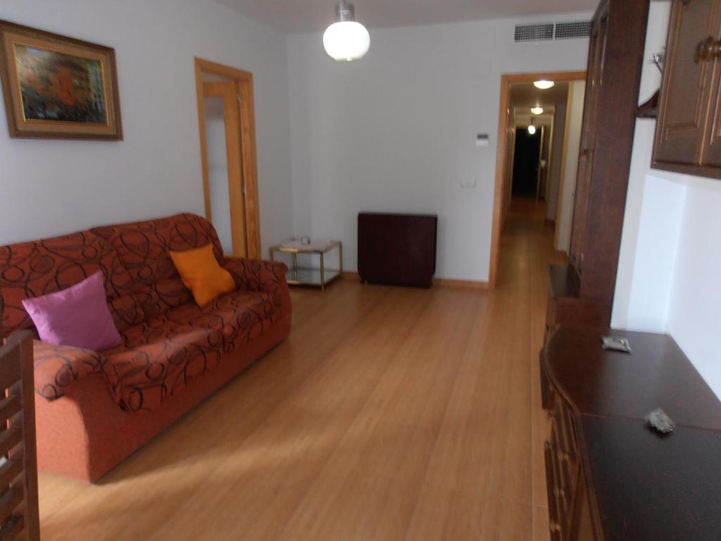 a living room with a brown couch and wooden floors at Maestro Bayarri HC-2D in Peñíscola