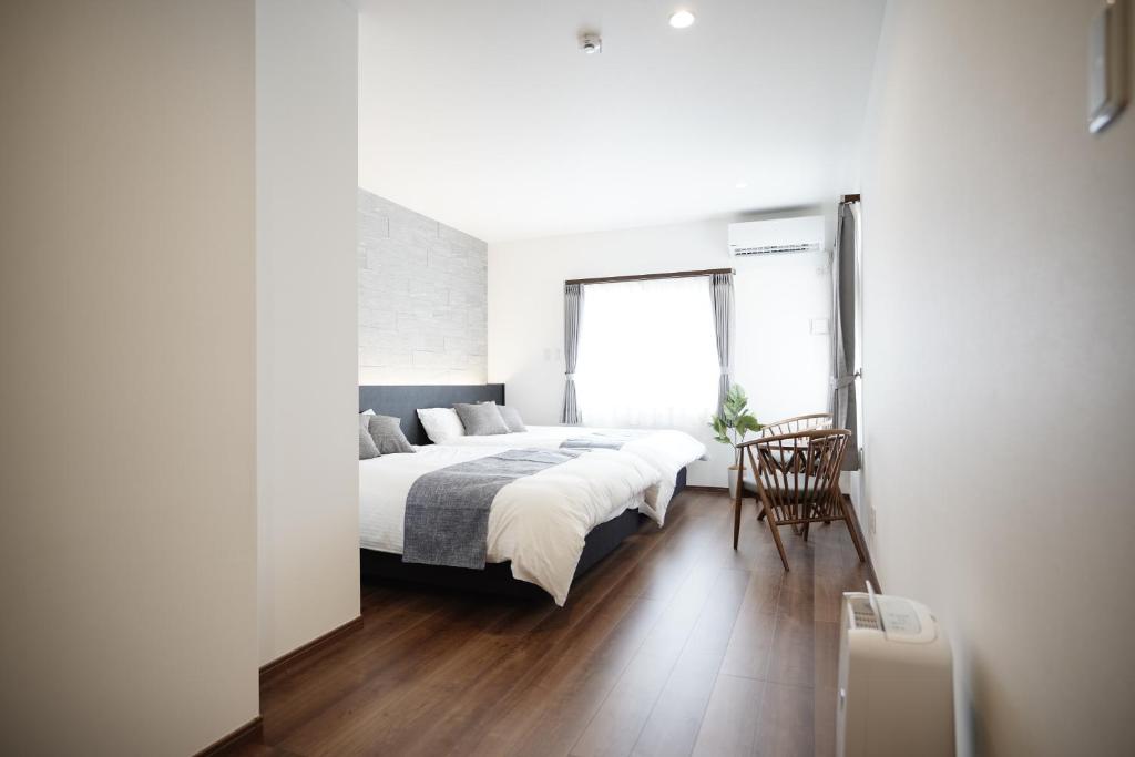 biała sypialnia z łóżkiem i oknem w obiekcie SENT RESORT VILLA Miyako-jima #MP1 w mieście Miyako-jima