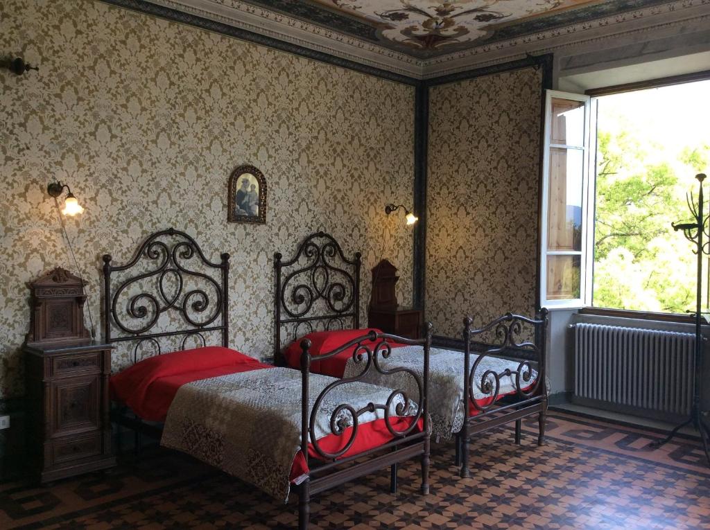 una camera da letto con un letto con lenzuola rosse e una finestra di Villa Carlotta a Sarzana