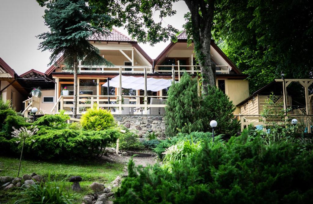 a house with a garden in front of it at Zajazd Bombonierka in Wikno