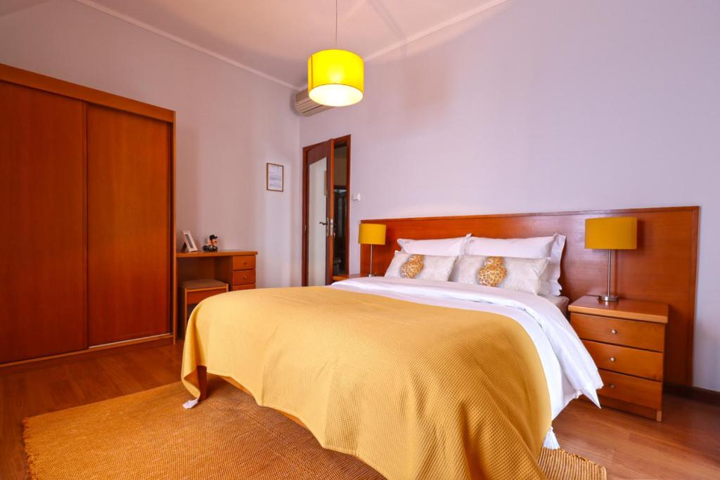 sypialnia z dużym łóżkiem i żółtym kocem w obiekcie Dolce Vianna - City Centre Rooms w mieście Viana do Castelo