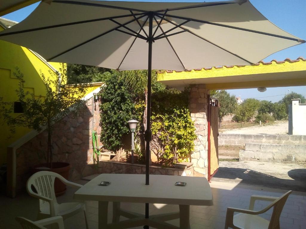 un tavolo con ombrellone su un patio di Locazione Turistica Torre Squillace a Sant'Isidoro