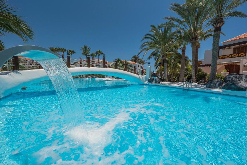 a swimming pool with a fountain in a resort at Parque Santiago 3 Luxery Apartment, Playa las Américas, Arona, Tenerife in Playa de las Americas