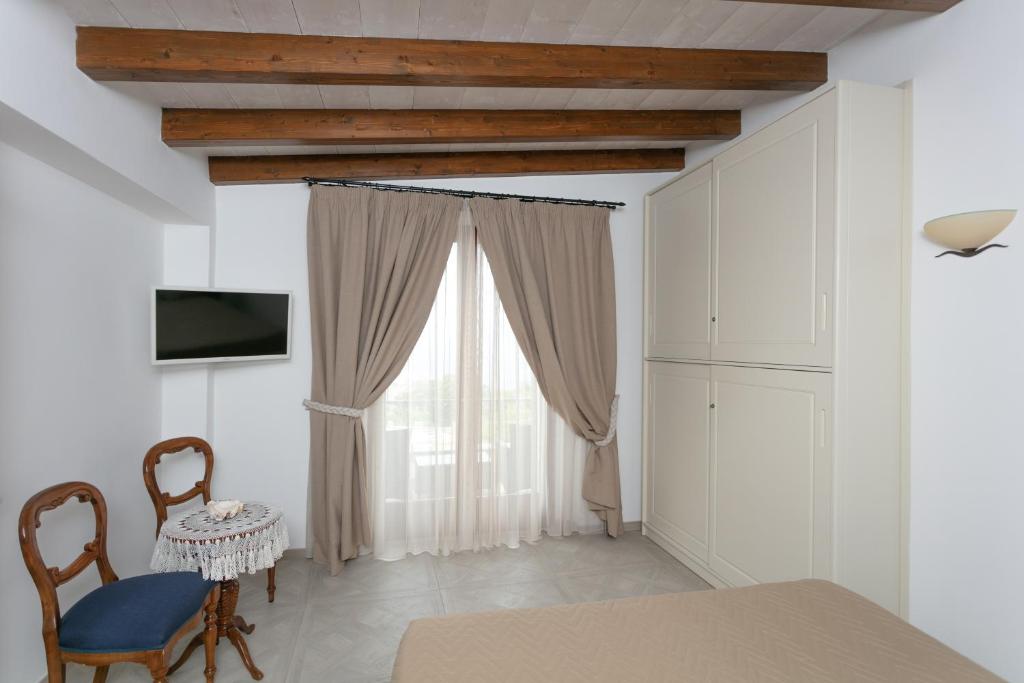 een eetkamer met een tafel en stoelen en een raam bij Aldarogi in Capri