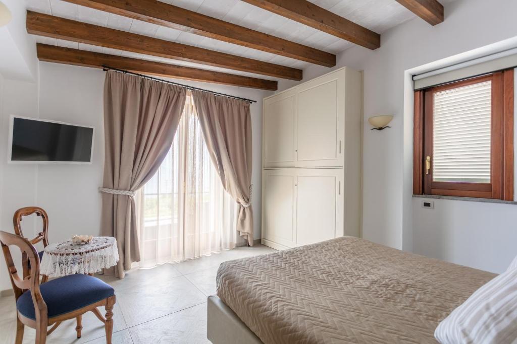 een slaapkamer met een bed, een stoel en een raam bij Aldarogi in Capri