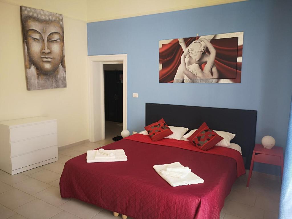 a bedroom with a bed with a red bedspread at Il Da Vinci casa vacanze in Giovinazzo