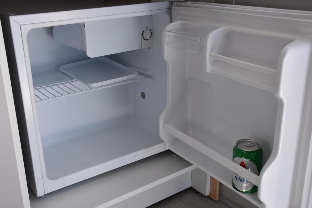 an open refrigerator with a can of soda in it at 4Bro Rooms Laerma Village in Láerma