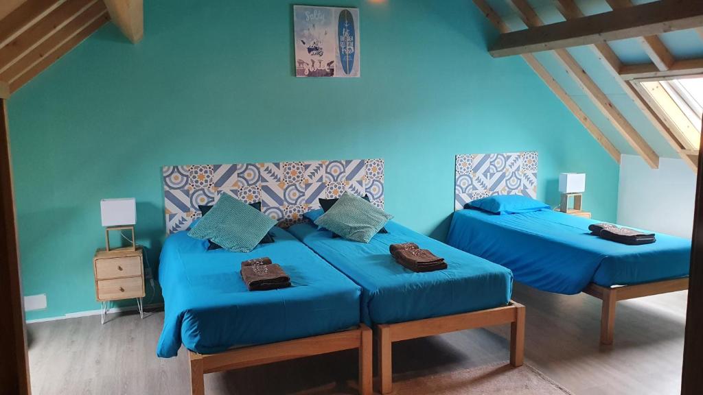 Dos camas en una habitación con paredes azules. en GO4SURF beach Lofts, en Peniche