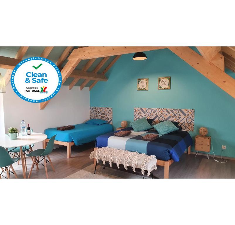 una camera da letto con pareti blu, un letto e un tavolo di GO4SURF beach Lofts a Peniche