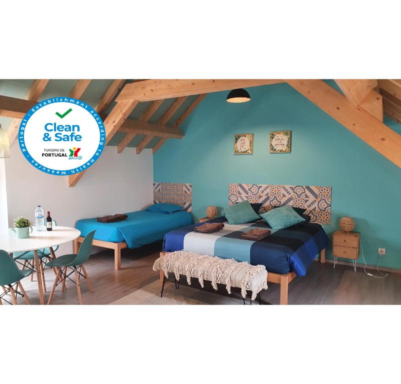 ペニシェにあるGO4SURF beach Loftsの青い壁のベッドルーム1室、ベッド1台、テーブルが備わります。