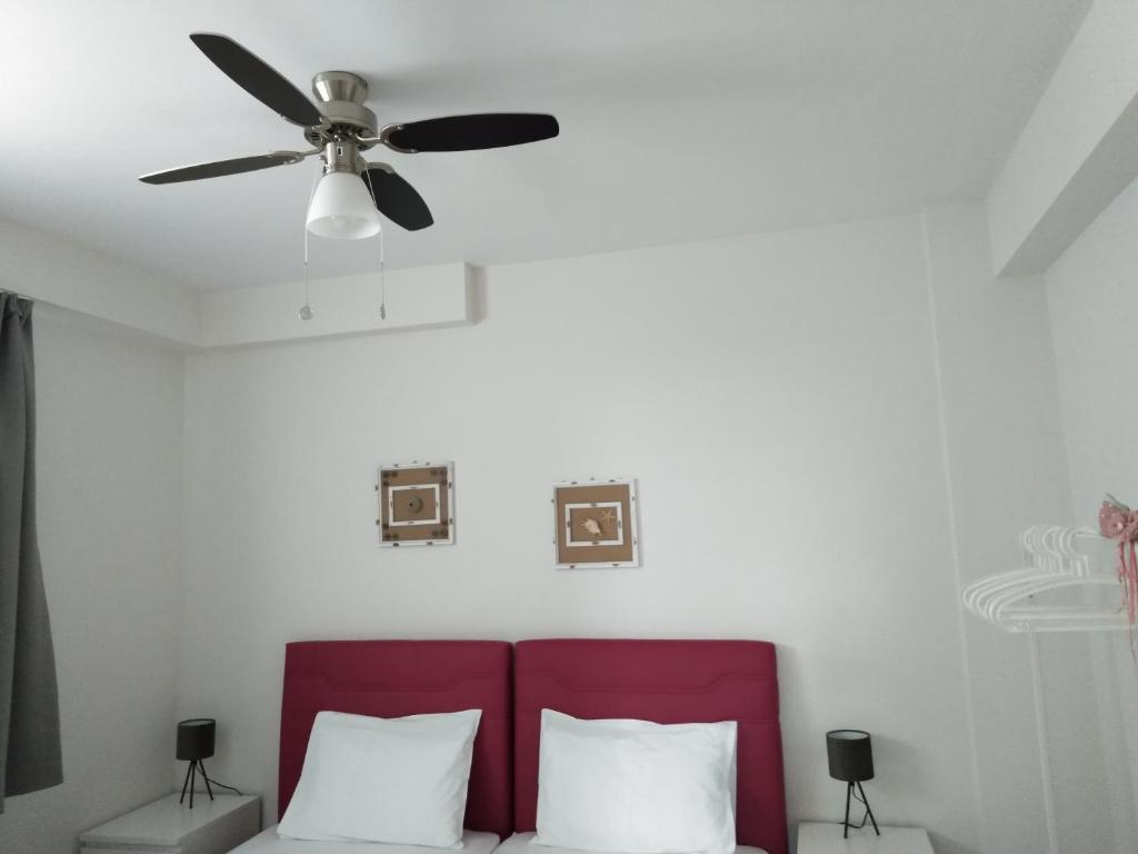 wentylator sufitowy nad łóżkiem z 2 poduszkami w obiekcie Marigeo Garden House w mieście Palaión Tsiflíkion
