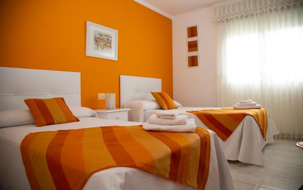 2 letti in una camera con pareti arancioni di Pico da Costa a Barreiros