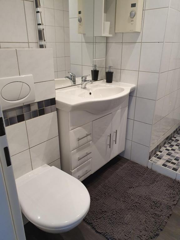 a white bathroom with a toilet and a sink at Casa Künske in Halle Westfalen