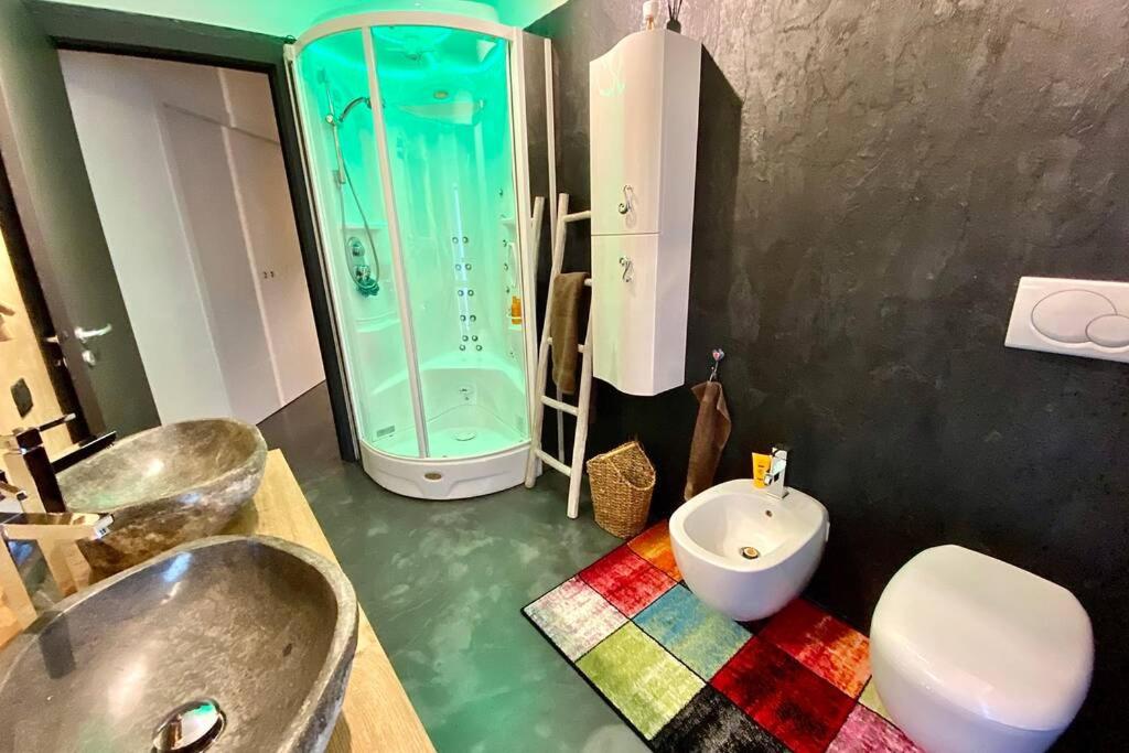 Spa Tiny Love Apartment close to Milan-Como-Malpensa في سارونّو: حمام مع حوض ودش ومرحاض