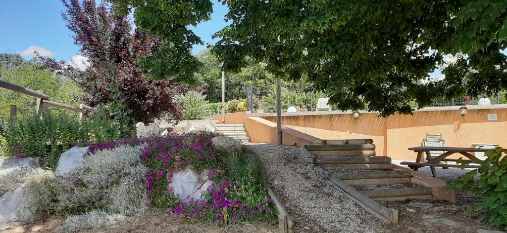 een tuin met een bank, trappen en bloemen bij LE GERLE in Mercurol