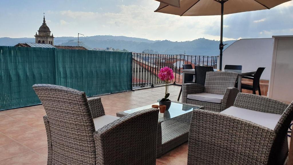 une terrasse avec des chaises et une table avec un parasol dans l'établissement Apartamento con terraza en el casco historico, à Ourense