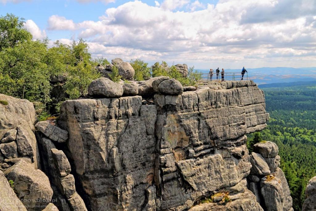 un grupo de personas de pie en la cima de una formación rocosa en Villasol, en Polanica-Zdrój