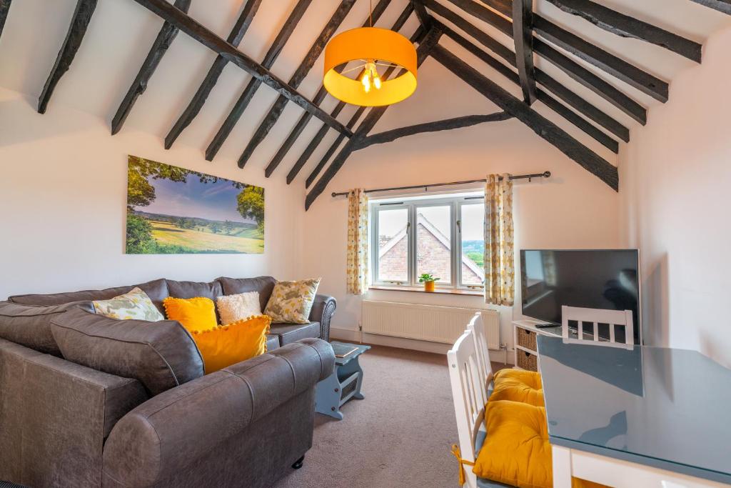 a living room with a couch and a tv at Valley Farm Holiday Cottages in Axminster